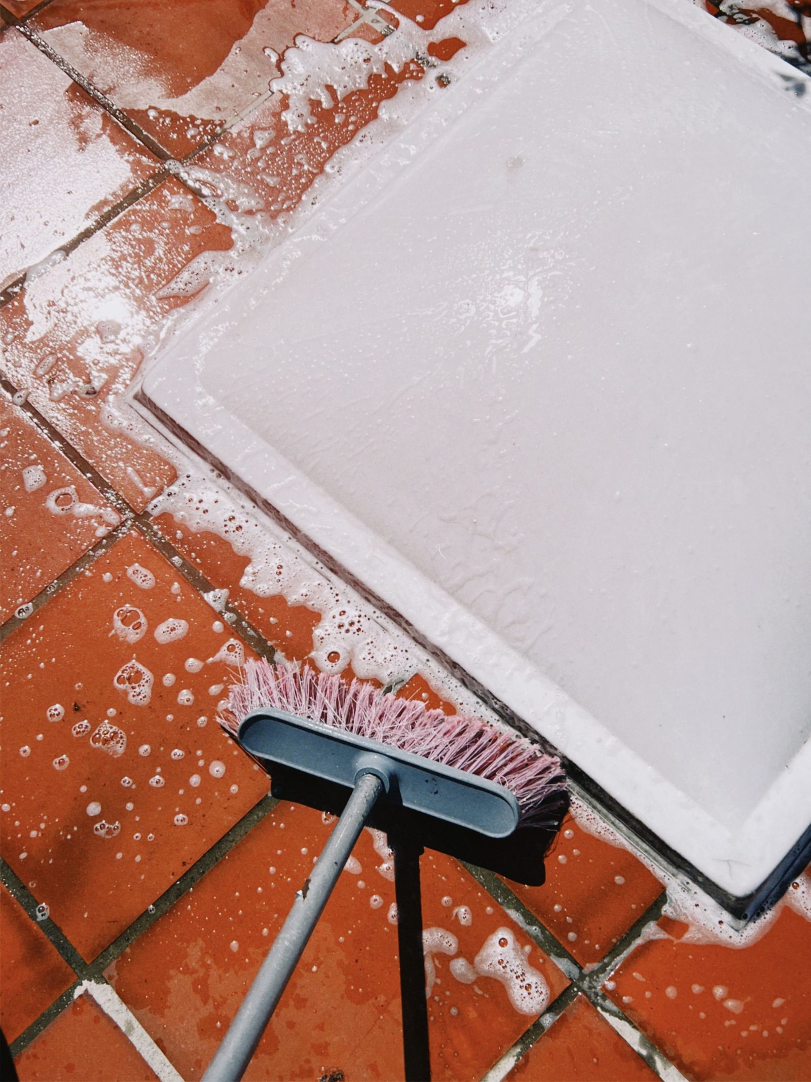 Patio tile being scrubbed with soap